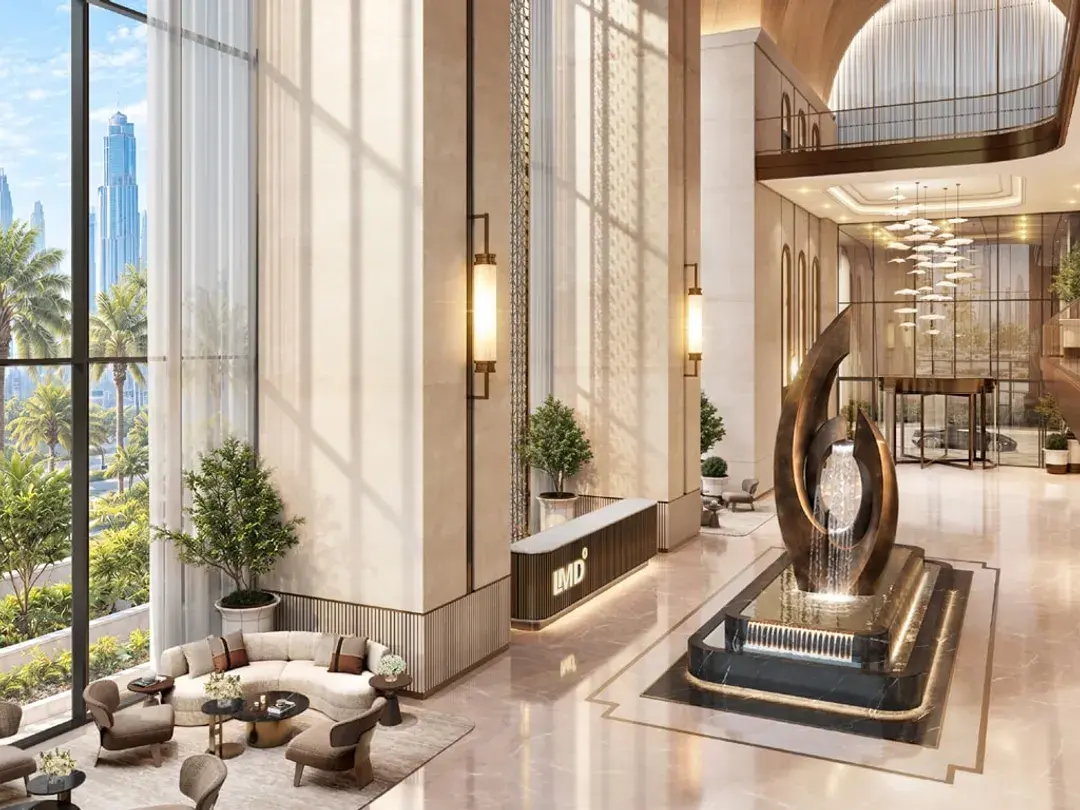 Double-height arrival lobby with a sculpture and lounge seating