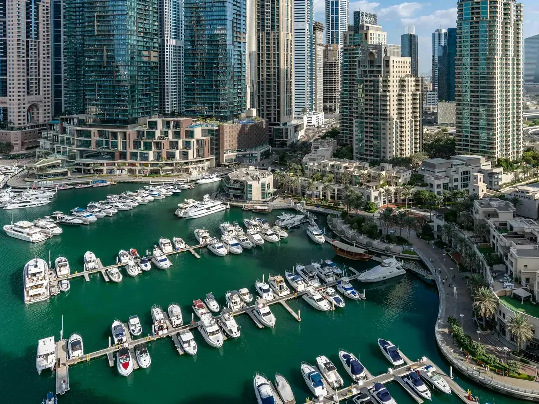 Yachts moored in Dubai Marina between residential towers