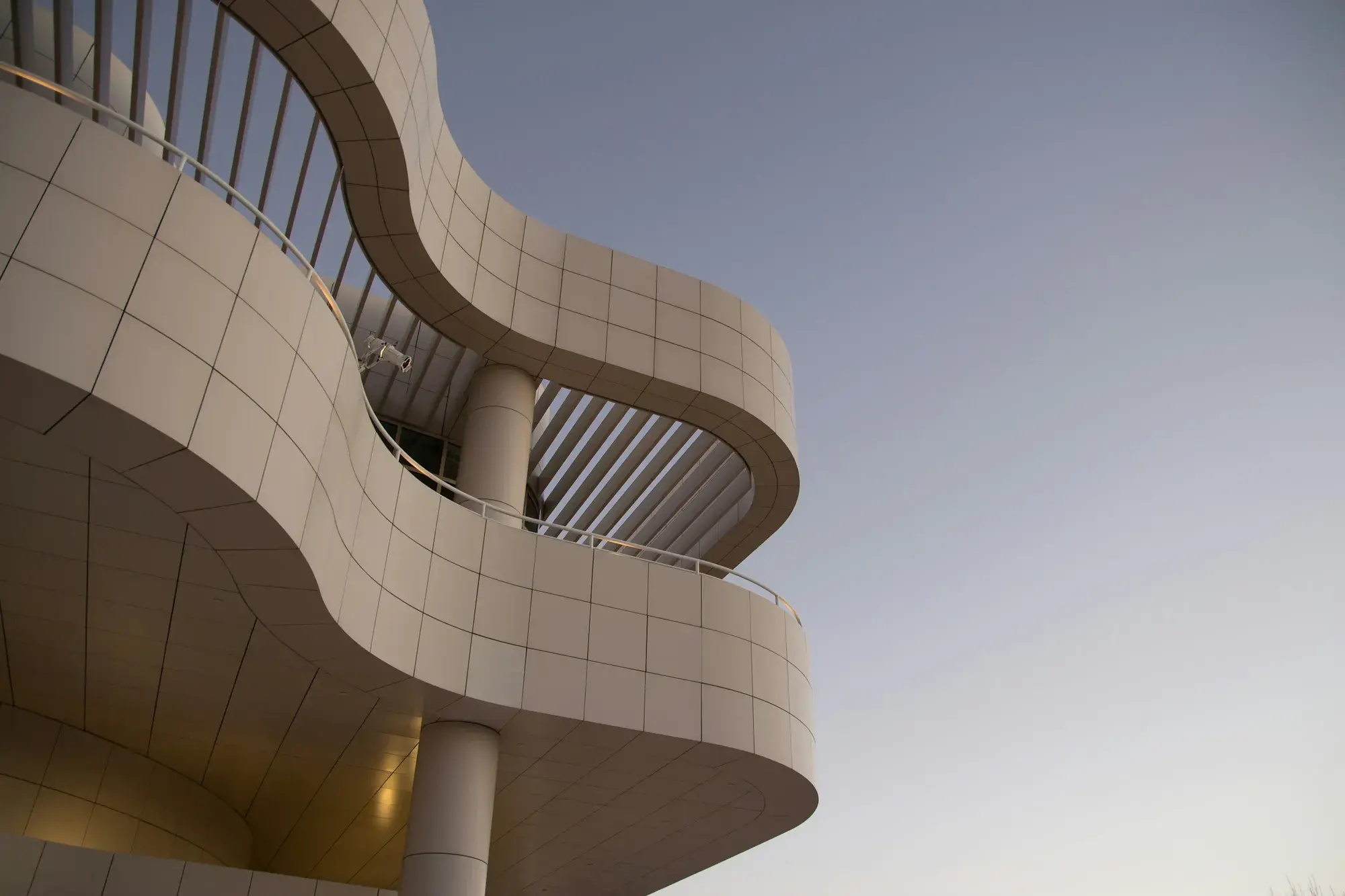 Curved travertine balconies against a clear sky